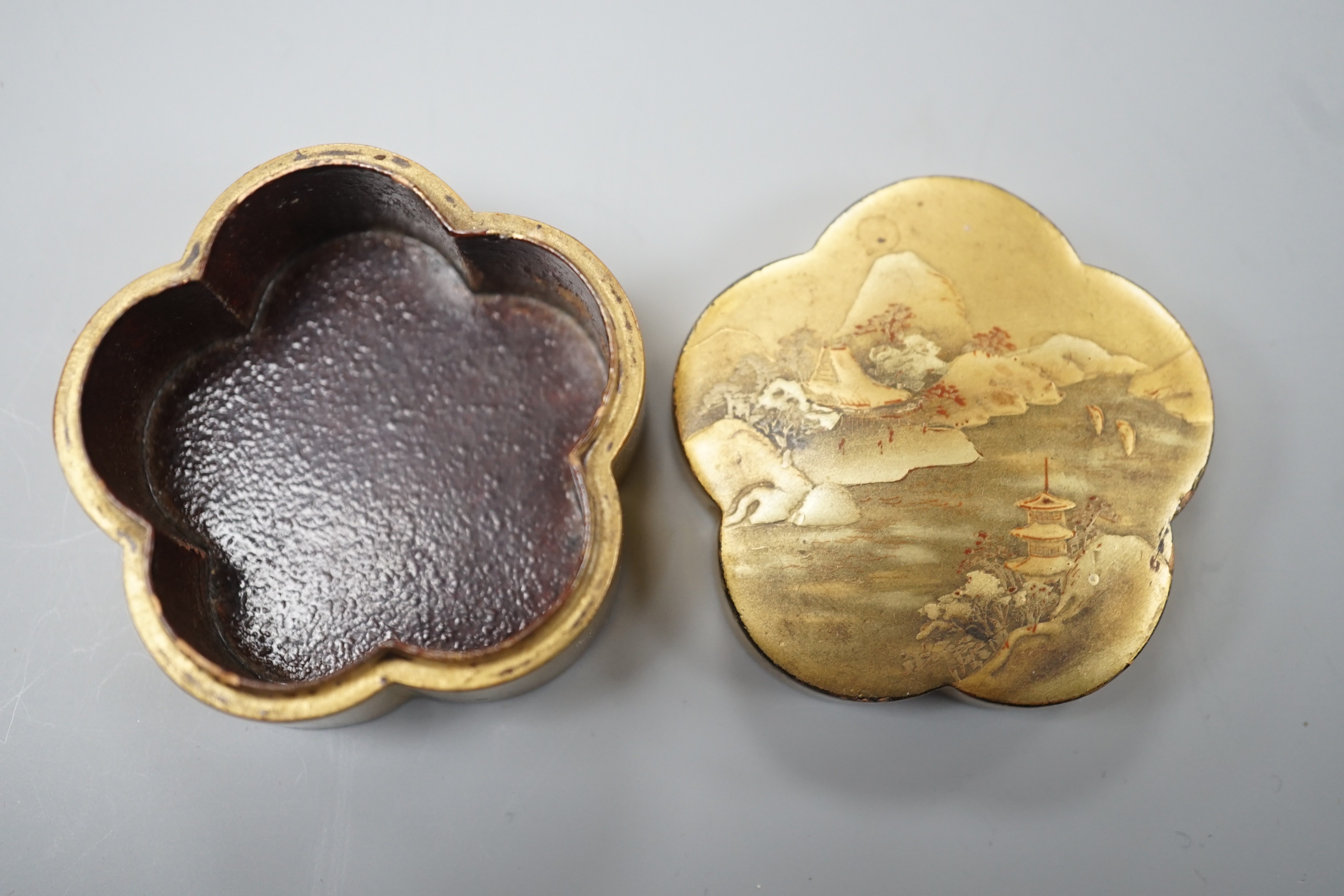 Two Japanese lacquer boxes, an ivory and bronze manju, an ivory ‘lion’ two-piece belt buckle and two simulated ivory items, late 19th/early 20th century, largest Box 11.5 cm